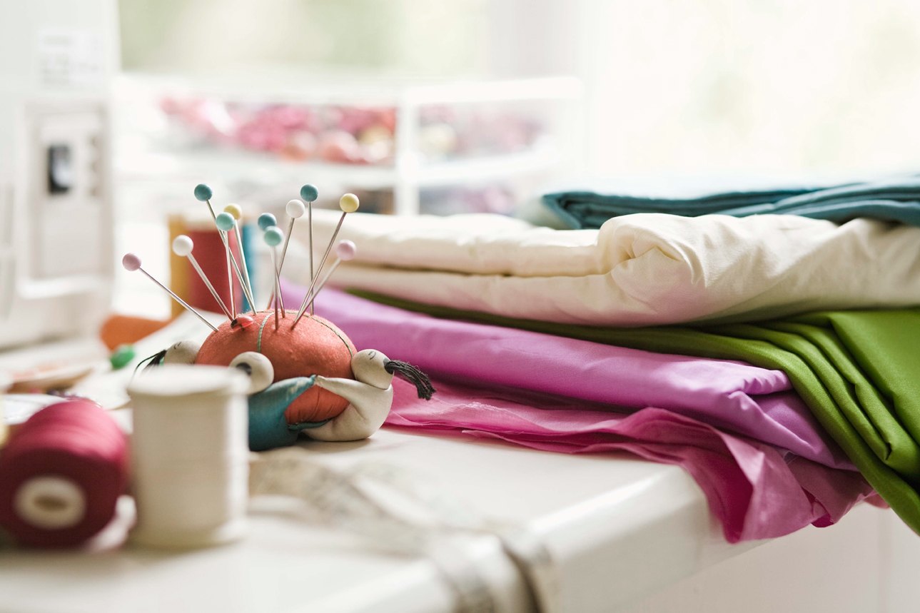 Colorful fabric, thread and pins in a sewing studio